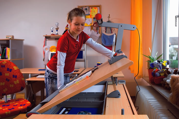 Moll Kinderschreibtisch Runner: Das Schrägstellen der Tischplatte geht kinderleicht. Der von Moll entwickelte Beschlag hat keine Scherstellen und wird abgebremst, so dass die Tischplatte nicht herunterfallen kann.